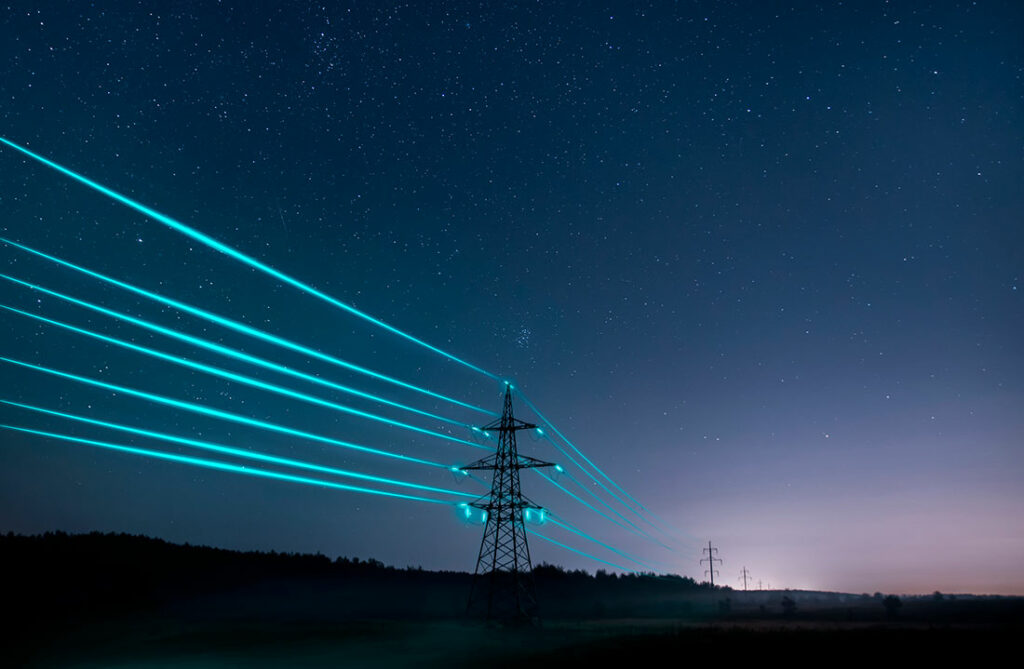 Illuminated transmission lines at night.